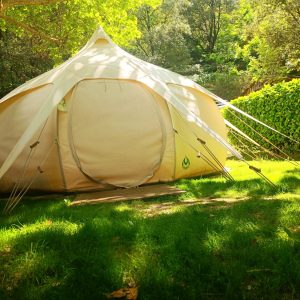 Tente géodésique en pleine nature, entourée de verdure luxuriante à Languedoc-Roussillon.