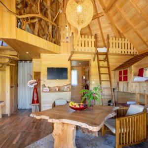 Cabane en bois avec un intérieur chaleureux et un escalier en colimaçon.