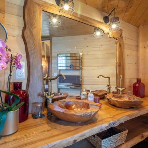Salle de bain en bois dun hébergement insolite en Aquitaine, avec vasques en bois.