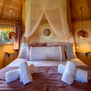 Cabane en bois cosy avec lit douillet et décoration chaleureuse.