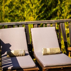 Chaises longues en bois dans un hébergement insolite en Aquitaine, entourées de verdure.