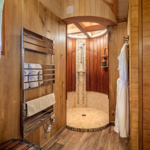 Douche en bois dans un hébergement insolite en Aquitaine, ambiance chaleureuse et naturelle.