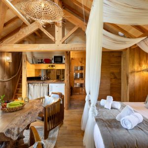 Cabane en bois avec lit douillet et décoration chaleureuse en Aquitaine.