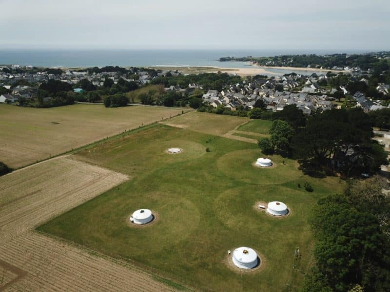 Hébergements insolites en yourtes, entourés de verdure et vue sur la mer.