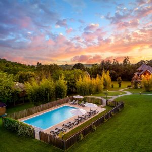 Hébergement insolite en Aquitaine : cabane en bois avec piscine entourée de verdure.
