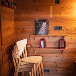 Hébergement insolite en bois avec chaises empilées et décoration chaleureuse.