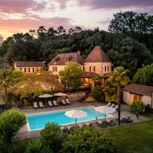Hébergement insolite en Aquitaine : charmante maison en pierre avec piscine et palmiers.