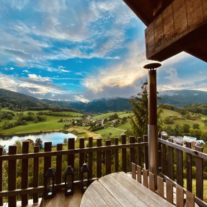 Cabane perchée avec vue panoramique sur le lac et les montagnes environnantes.