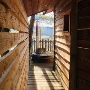 Cabane perchée en bois avec vue panoramique sur la nature environnante.