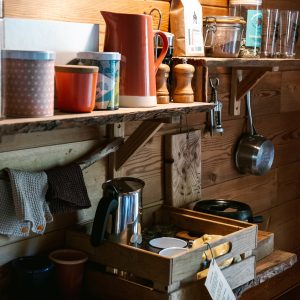 Hébergement insolite en Auvergne-Rhône-Alpes, intérieur en bois chaleureux avec vaisselle colorée.