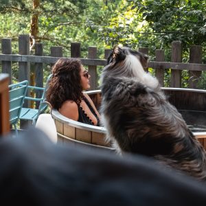 Hébergement insolite en Auvergne-Rhône-Alpes avec baignoire extérieure et vue verdoyante.
