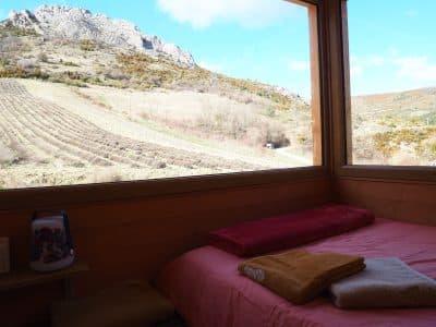 Cabane en bois avec vue sur les montagnes et champs, ambiance chaleureuse et cosy.