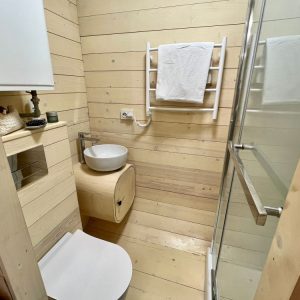 Salle de bain moderne en bois dans un hébergement insolite en Auvergne-Rhône-Alpes.
