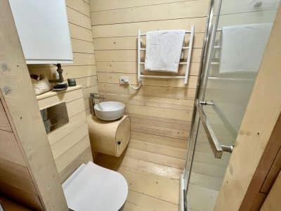 Salle de bain moderne en bois dans un hébergement insolite en Auvergne-Rhône-Alpes.