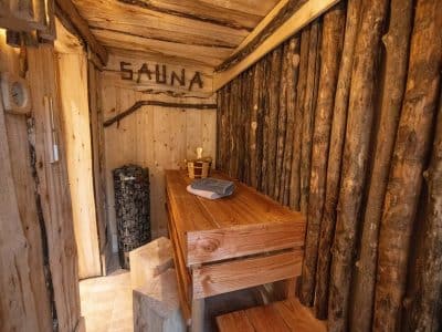 Sauna en bois naturel, ambiance chaleureuse et rustique, idéal pour se détendre.