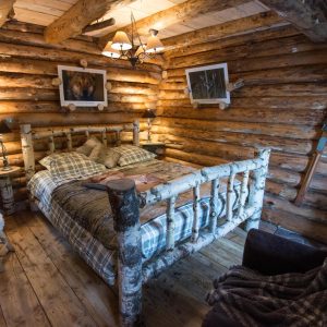 Chalet en bois dans le Grand-Est, avec un lit en rondins et une ambiance chaleureuse.