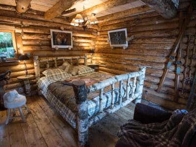 Chalet en bois dans le Grand-Est, avec un lit en rondins et une ambiance chaleureuse.