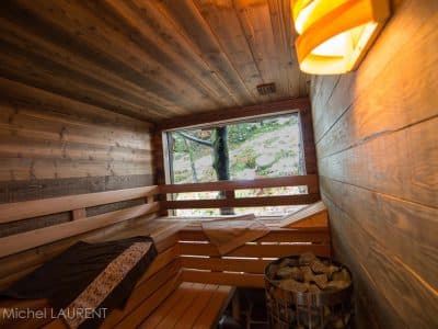 Sauna en bois chaleureux avec vue sur la nature, idéal pour un séjour relaxant.