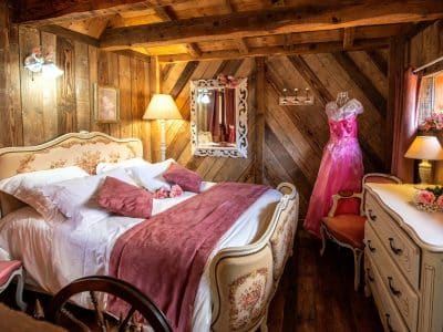 Chalet romantique en bois avec lit double et décoration vintage élégante.