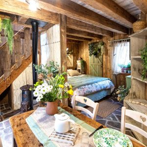 Cabane en bois cosy avec une décoration florale et un coin repas chaleureux.