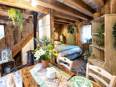 Cabane en bois cosy avec une décoration florale et un coin repas chaleureux.