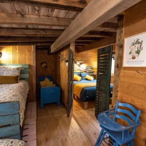 Chalet en bois chaleureux avec lits colorés et décor rustique à Grand-Est.