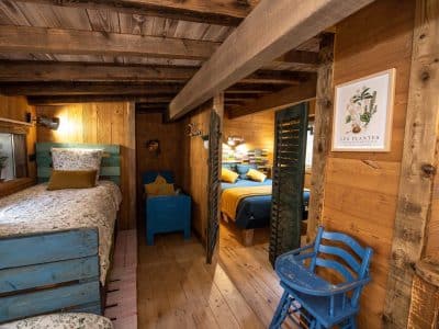 Chalet en bois chaleureux avec lits colorés et décor rustique à Grand-Est.