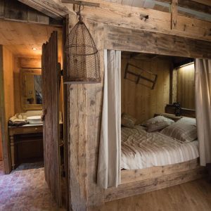 Hébergement insolite en bois à Grand-Est, avec une chambre cosy et des détails rustiques.