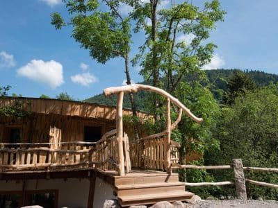 Hébergement insolite en bois à Grand-Est, avec une terrasse en bois naturel et verdure.