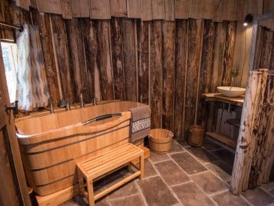 Hébergement insolite en bois avec baignoire en bois et murs rustiques à Grand-Est.