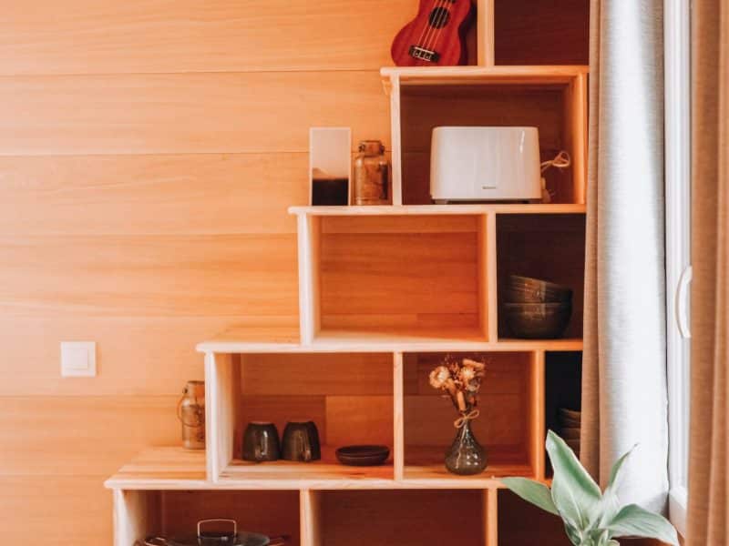 Chalet en bois chaleureux avec étagères design et décoration conviviale.