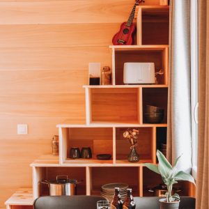 Hébergement insolite en bois en Nouvelle-Aquitaine, avec étagères créatives et ukulélé.