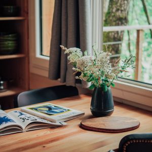 Cabane en bois en Nouvelle-Aquitaine, avec une table en bois et un vase de fleurs.