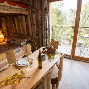 Hébergement insolite en bois avec lit douillet et vue sur la nature.