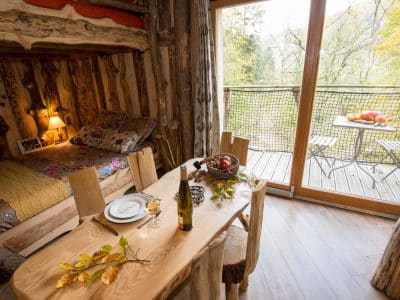 Hébergement insolite en bois avec lit douillet et vue sur la nature.