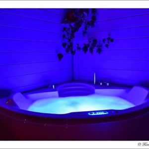 Hébergement insolite à Limousin avec un jacuzzi illuminé en bleu, parfait pour se détendre.