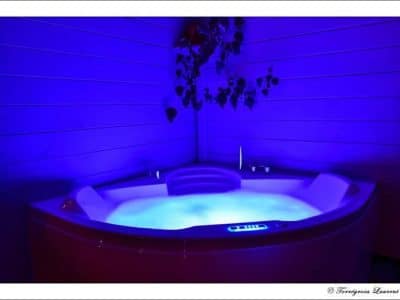 Hébergement insolite à Limousin avec un jacuzzi illuminé en bleu, parfait pour se détendre.