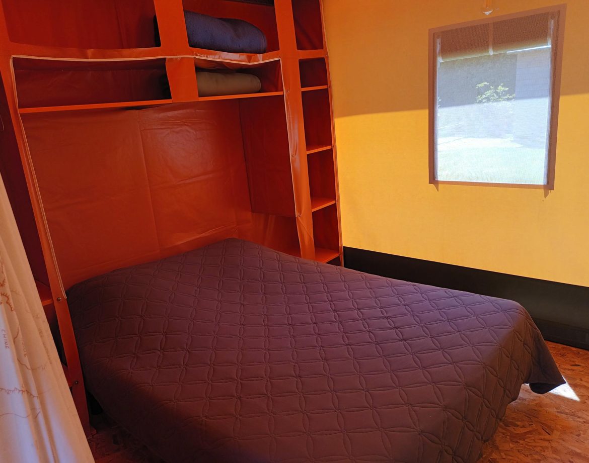 Hébergement insolite en Pays de la Loire : chambre colorée avec lit double et rangement.