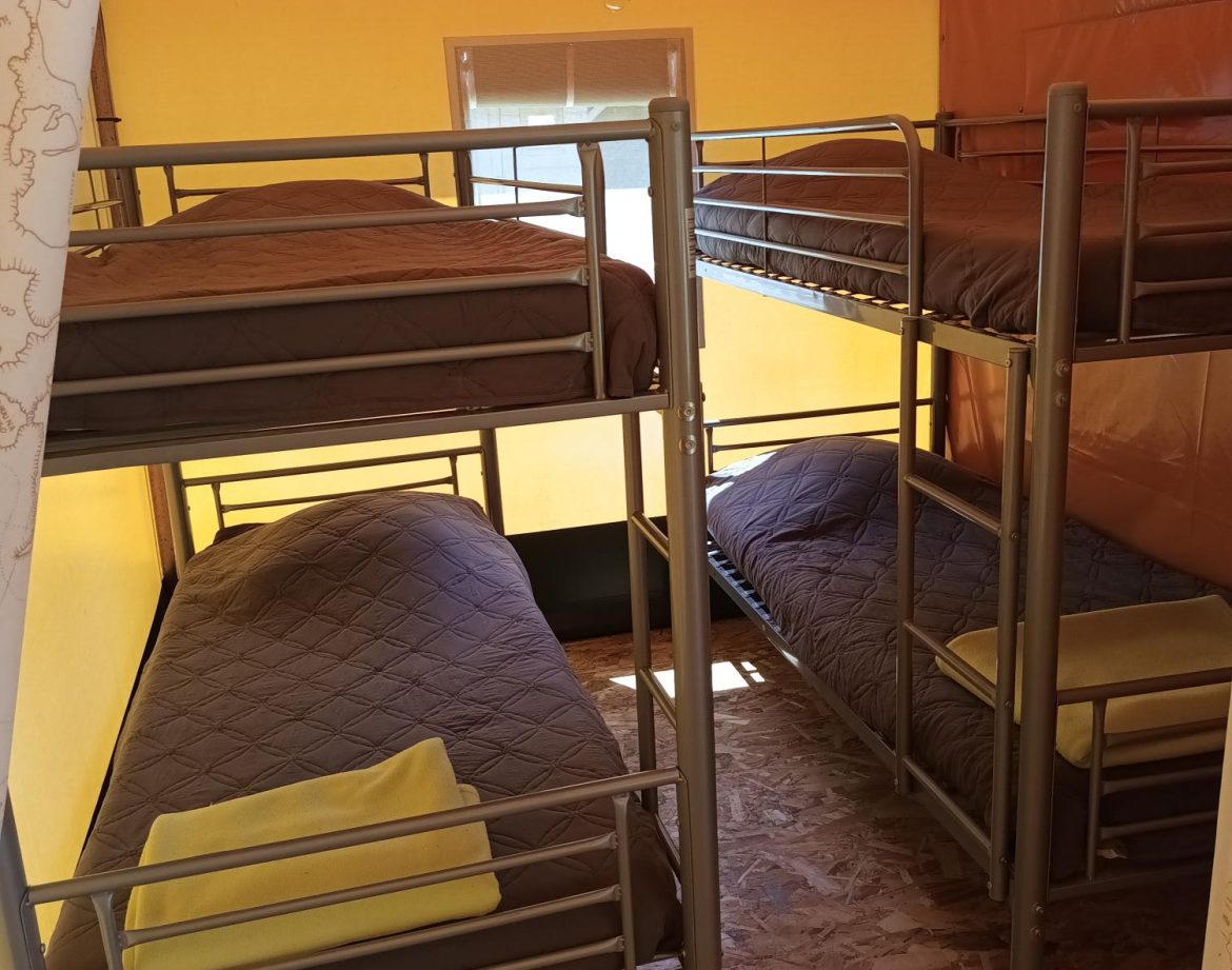 Chambre partagée en tente avec lits superposés et décoration colorée.