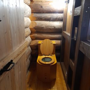 Toilette en bois dans un hébergement insolite en Auvergne-Rhône-Alpes, ambiance chaleureuse.