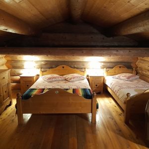 Chalet en bois chaleureux avec lits en bois et éclairage doux, idéal pour un séjour cocooning.