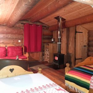 Chalet en bois chaleureux avec poêle à bois et décor rustique en Auvergne-Rhône-Alpes.