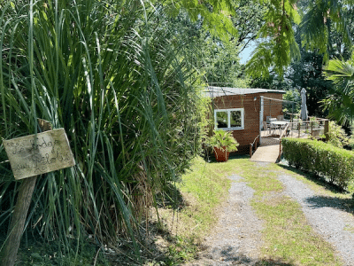 Chalet en bois entouré de verdure, avec une terrasse ensoleillée à Aquitaine.