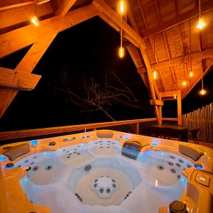 Hébergement insolite en Midi-Pyrénées avec jacuzzi lumineux sous une belle charpente en bois.