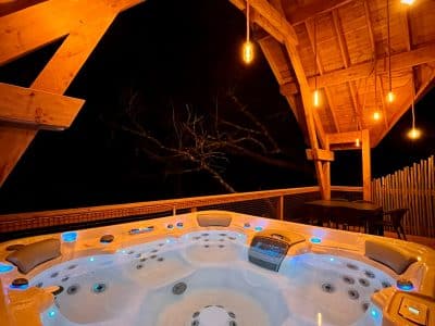 Hébergement insolite en Midi-Pyrénées avec jacuzzi lumineux sous une belle charpente en bois.