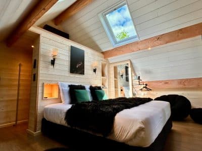 Chalet moderne en Midi-Pyrénées, avec lit douillet et grandes fenêtres lumineuses.