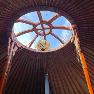 Intérieur dune yourte en Midi-Pyrénées, avec un puits de lumière circulaire.