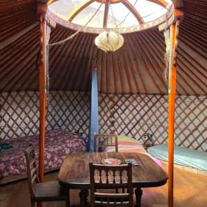 Yourte chaleureuse en Midi-Pyrénées, avec un plafond en verre et un mobilier en bois.