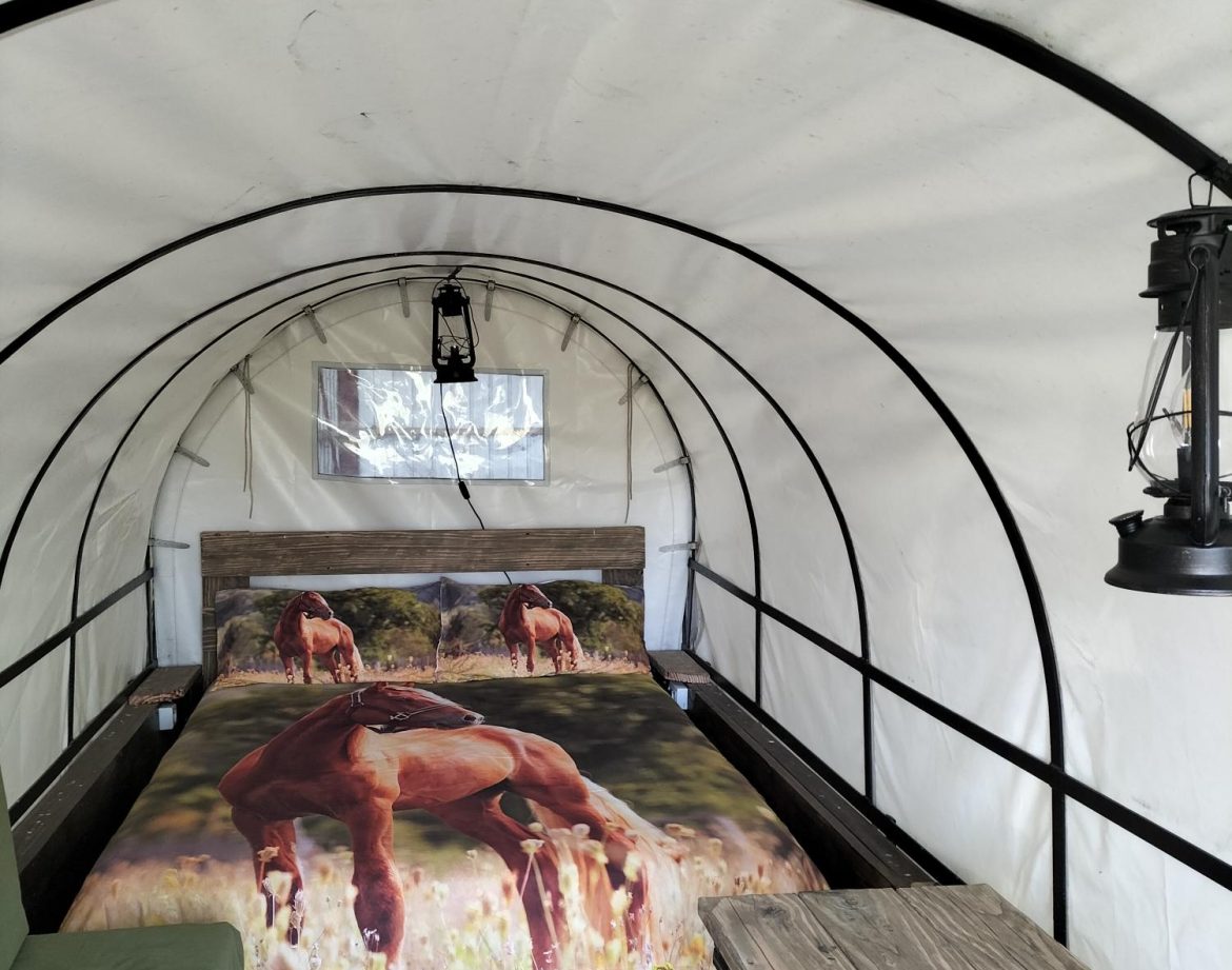 Hébergement insolite en Pays de la Loire : tente avec lit décoré de chevaux.