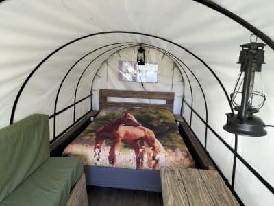 Hébergement insolite en Pays de la Loire : tente ronde avec lit et décor de chevaux.